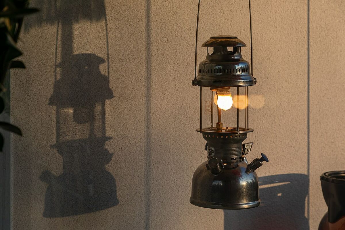 A worn pressure lantern glowing in low evening sun